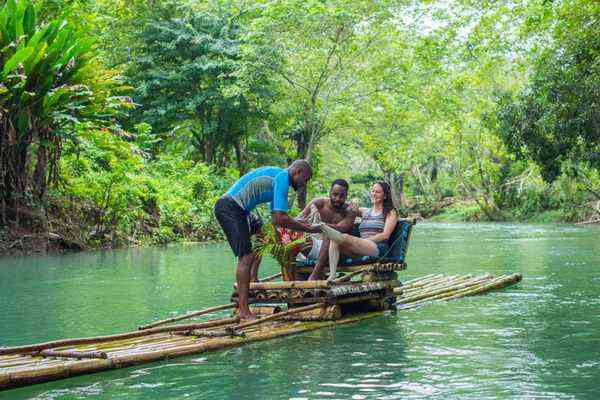 White River Bamboo Rafting Jamaica - couple on bamboo raft through lush green jungle river