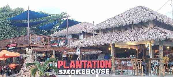 Plantation Smokehouse Jamaica - outdoor restaurant thatched roof We Love Food sign