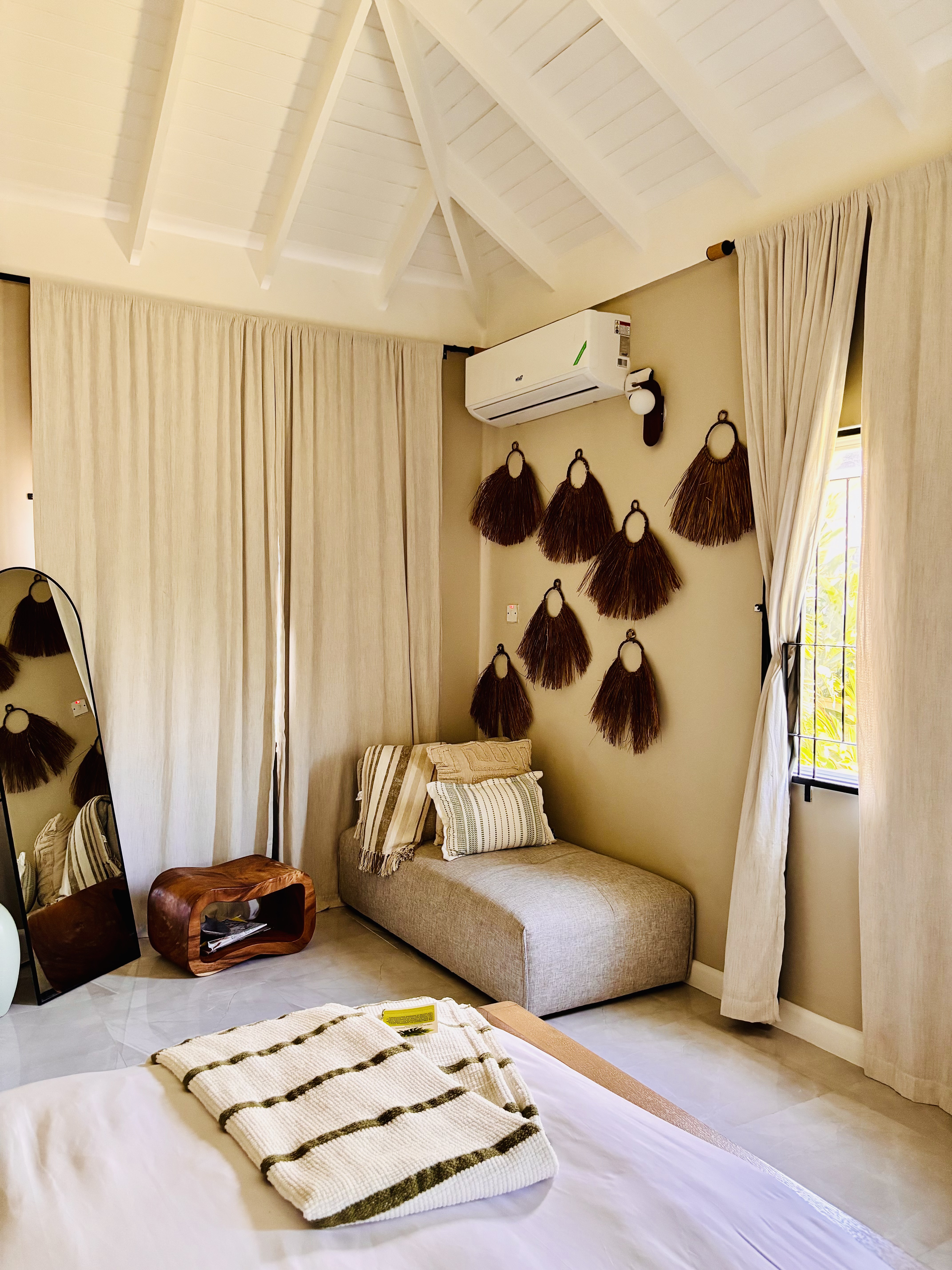 Master bedroom with woven wall hangings and chaise lounge